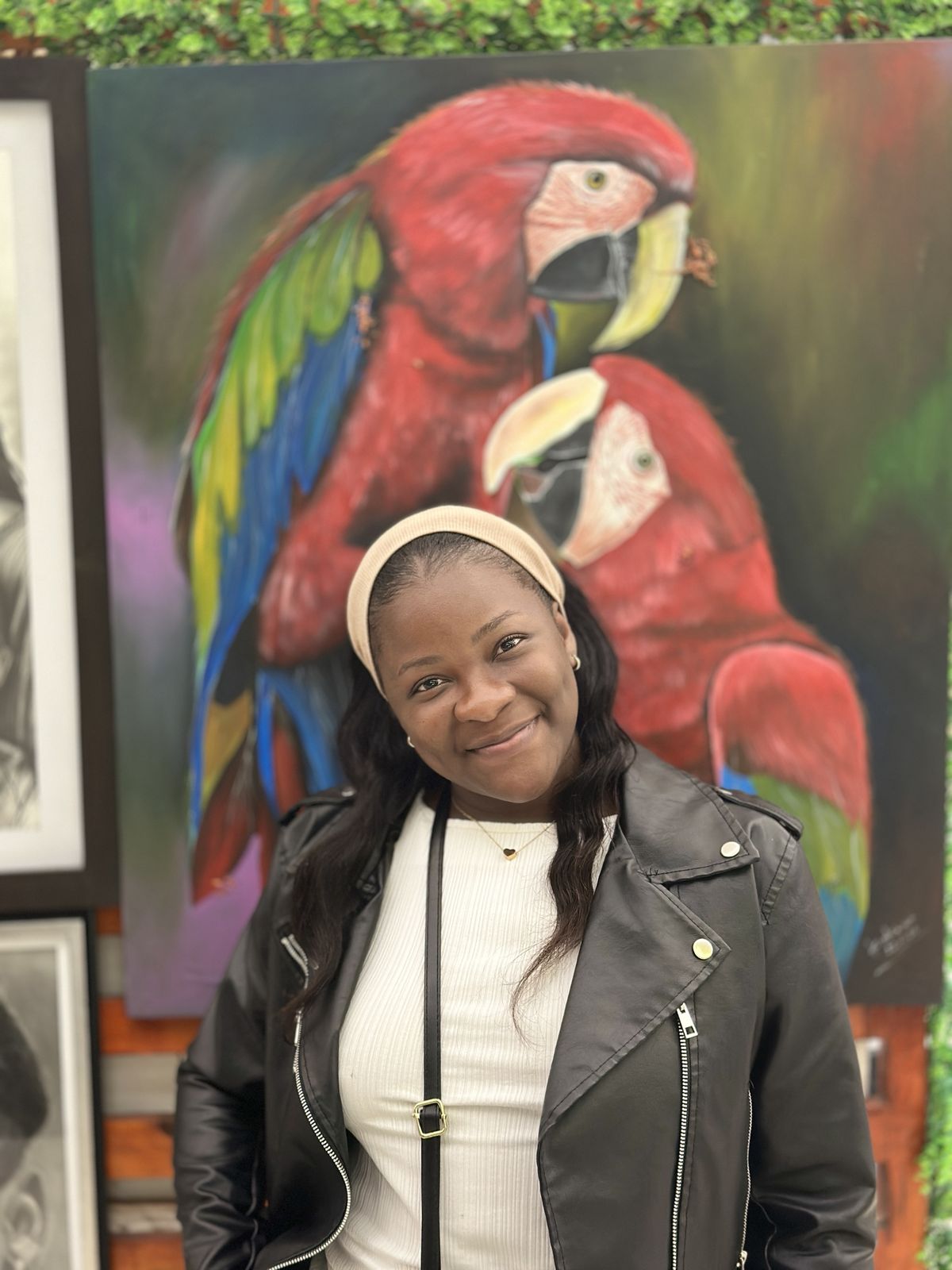 Suzana à frente de um quadro de araras